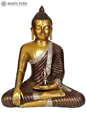 14" Brass Lord Buddha Idol with Dorje | Handmade | Made in IndiaIn the sacred iconography of Tibetan Buddhism, the representation of Lord Buddha alongside a Dorje carries profound spiritual significance. Lord Buddha, the enlightened sage, is venerated for